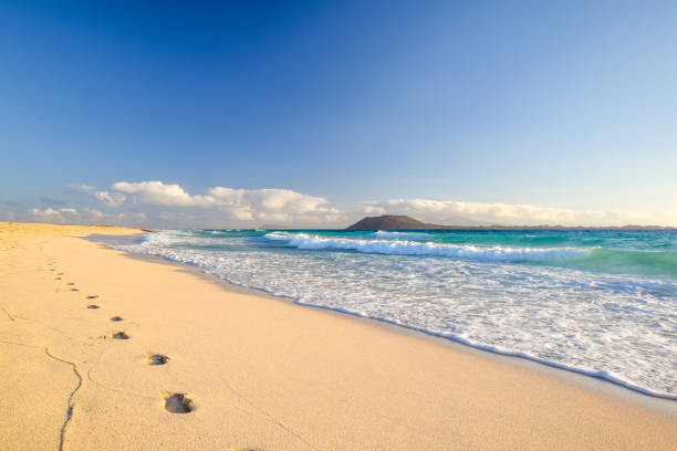 Stunning morning view of the islands of Lobos and Lanzarote seen from Corralejo Beach (Grandes Playas de Corralejo) on Fuerteventura, Canary Islands, Spain, Europe. Beautiful footprints in the sand. stock photo