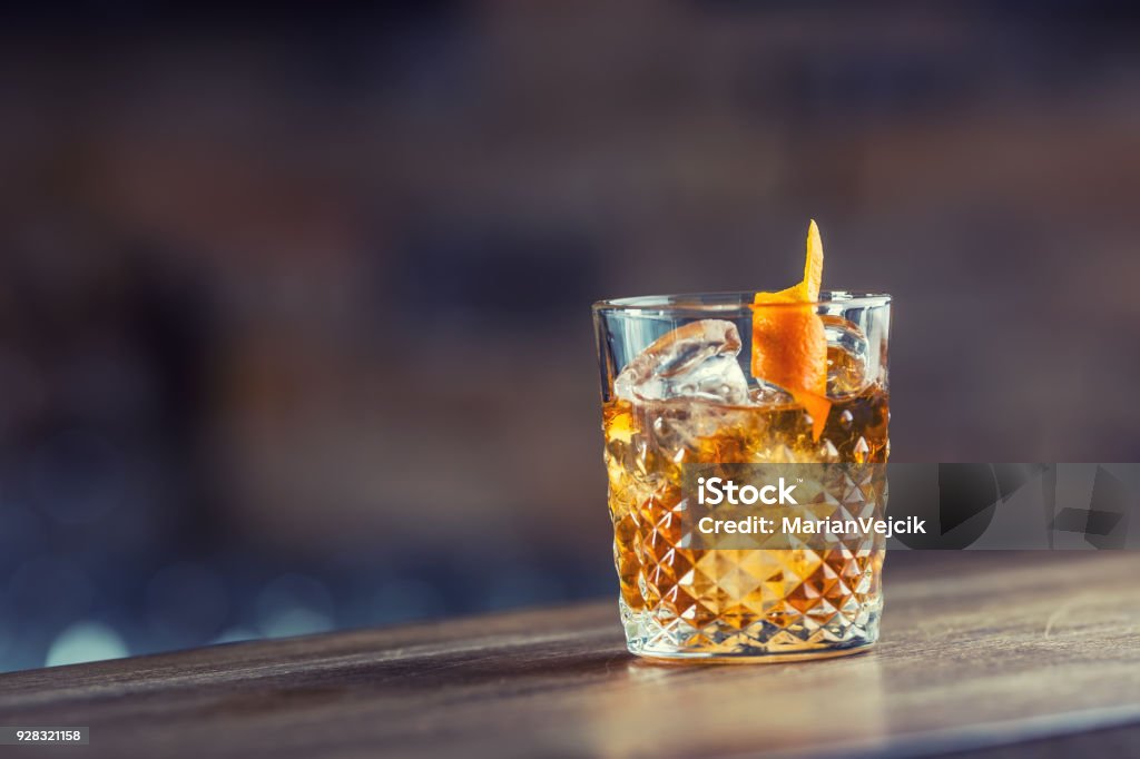 Old fashioned classic cocktail drink in crystal glass on bar counter Old fashioned classic cocktail drink in crystal glass on bar counter. Cocktail Stock Photo