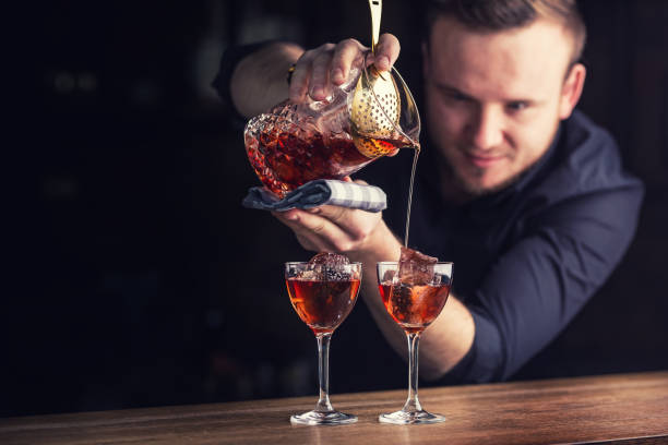 istock Bartender pouring cocktail alcoholic drink Manhattan. Barman in pub or restaurant  preparing a cocktail drink 928321178