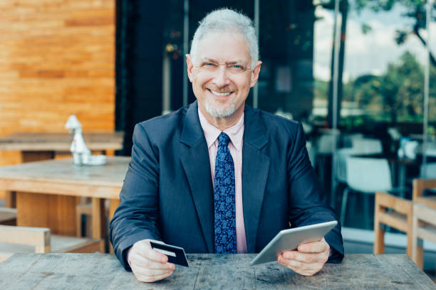 istock Smiling Senior Business Man with Credit Card 928324362