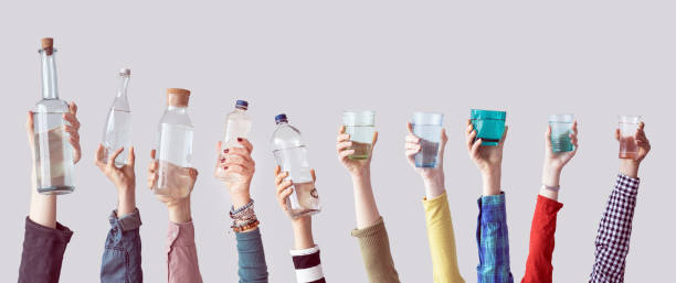 istock Different people holding water bottles and glass 928324690