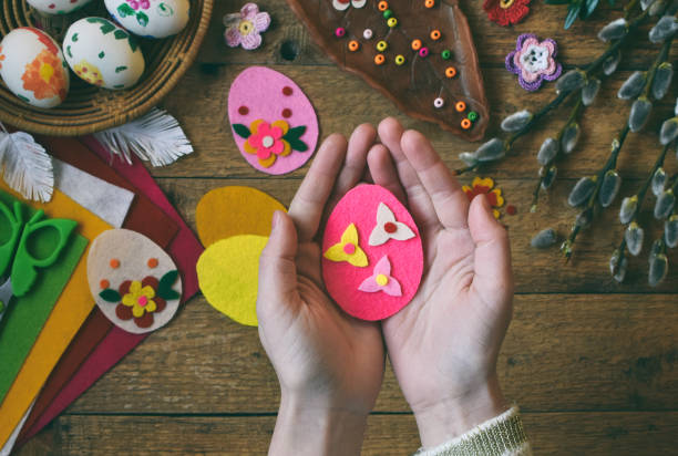 istock Making of handmade easter eggs from felt with your own hands. Children's DIY concept. Making Easter decoration or greeting card 928325162