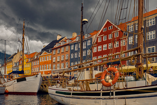 Dramatic view of famous Nyhavn harbor with boats in the historical city centre.