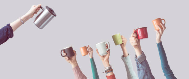 istock Many different arms raised up holding coffee cup 928328382