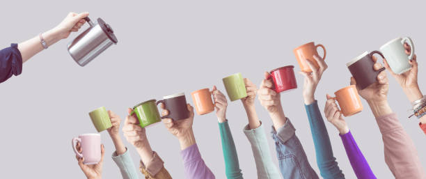 istock Many different arms raised up holding coffee cup 928328504