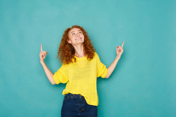 Excited redhead woman pointing up
