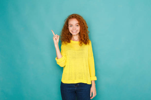 istock Attractive young woman pointing her finger up 928328682