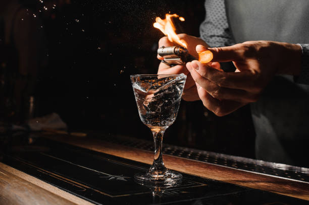 istock Bartender making flame over the alcoholic cocktail with orange peel 928331424