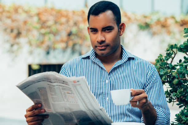 istock Handsome Hispanic Man with Coffee and Newspaper 928334162