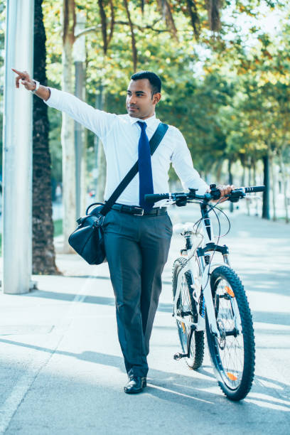 istock Hispanic Office Worker with Bike Raising Hand 928334182