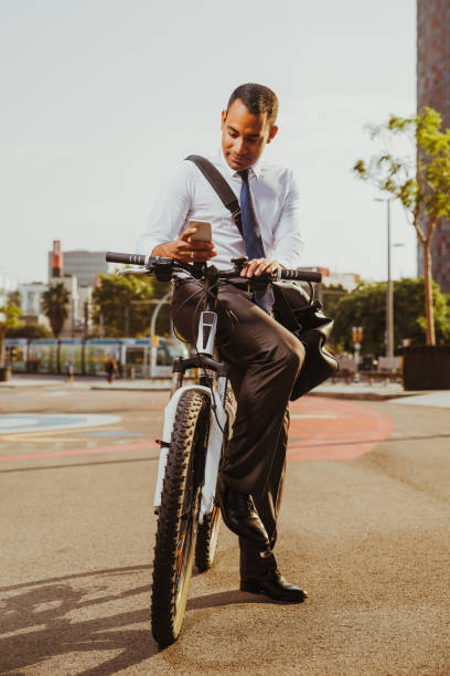 istock Happy Hispanic Businessman on Bike Texting Message 928334186