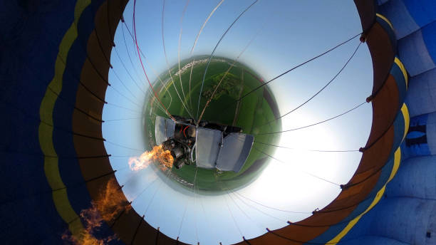 Hot air balloon is inflated in the early morning hours by a Latino man with an average age of 50 years who is the pilot in charge of providing this experience to tourists.