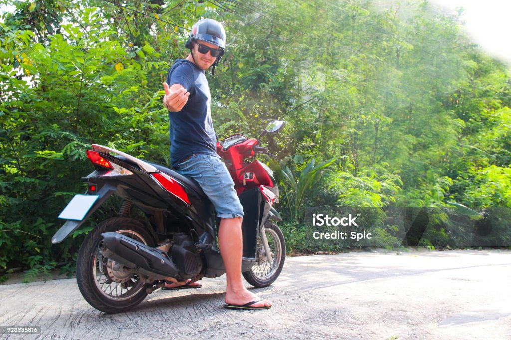 Un Uomo Con Un Casco Seduto Su Uno Scooter - Fotografie stock e altre  immagini di Adulto - Adulto, Ambientazione esterna, Assistenza - iStock