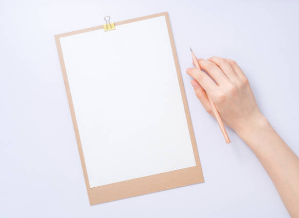 istock female hands with pencil writing on paper 928336834
