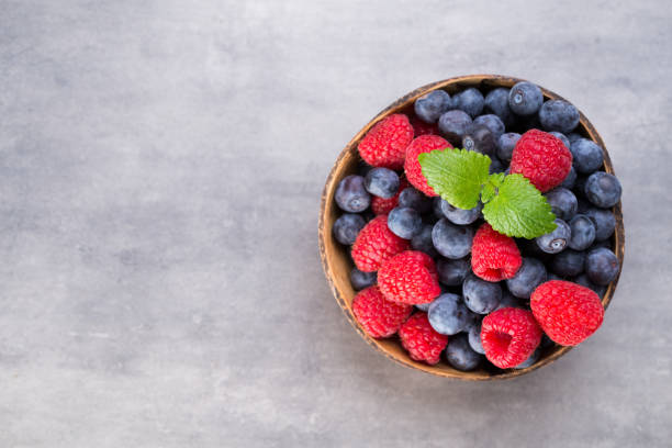 istock Juicy and fresh blueberries with green mint on rustic gray table. 928346752