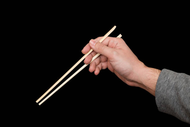 istock Hand Holding Chopsticks Isolated On Black Background 928351334