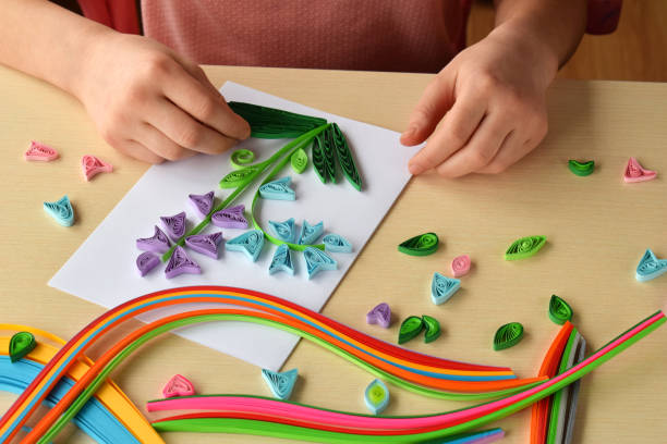 istock Quilling technique. Girl making decorations or greeting card. Paper strips, flower, scissors. Handmade crafts on holiday: Birthday, Mother's or Father's Day, March 8, Wedding. Children's DIY concept. 928367524