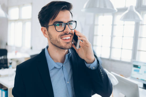 istock Smiling businessman taling on phone at workplace 928369556
