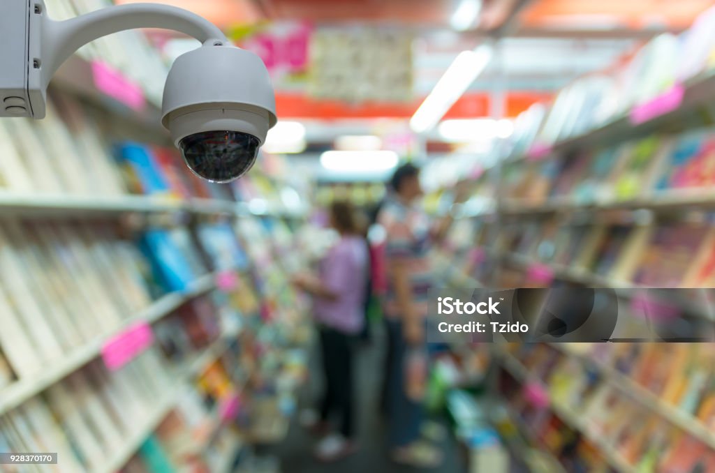 Security camera monitoring on the Abstract blurred photo of book store with people background, education shopping base on security concept Office Stock Photo
