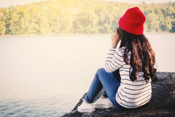 istock Woman Sitting On Rock At Lakeshore 928372458