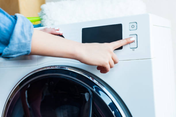 istock close-up partial view of woman using washing machine at home 928381822
