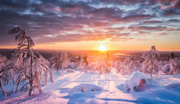 Panoramic view of beautiful winter wonderland scenery in scenic golden evening light at sunset with clouds in Scandinavia, northern Europe