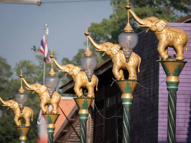 Photo of Golden Fighting Elephants Statue on Top of The Pillar in The Purple Town