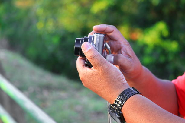 istock hand holding camera photograph in nature background 928395468