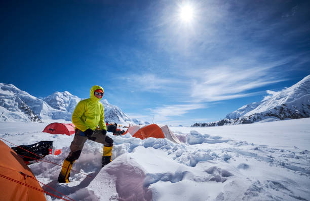 Mountaineer in camp 01 on the glacier on the West Buttress route. On a beautiful sunny day, on Denali.