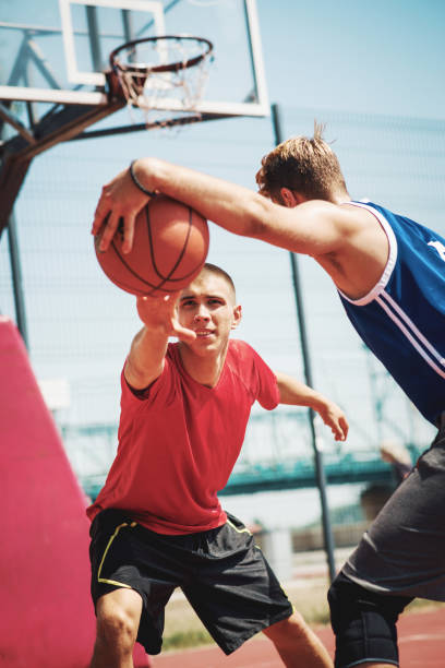 istock Two man playing one on one basketball 928399376