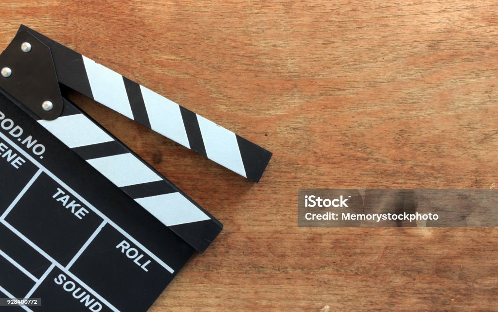 closeup movie clapper board on wood table with soft-focus and over light in the background Movie Stock Photo