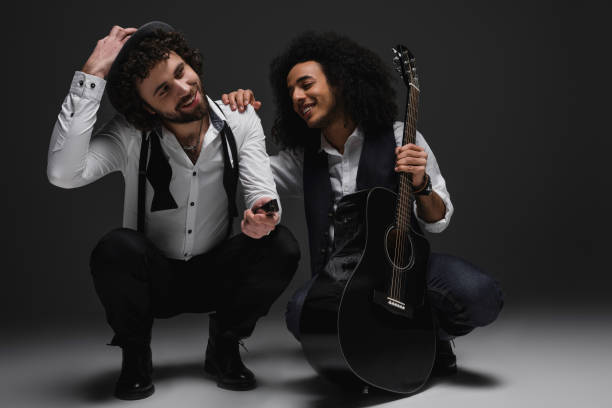istock duet of happy musicians with guitar and harmonica sitting squat 928401340