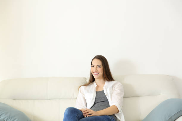 istock Homeowner sitting on a couch looking at camera 928401610
