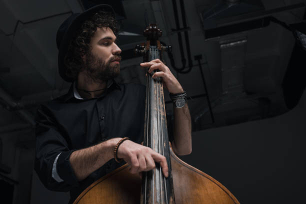 istock bottom view of young handsome musician playing contrabass 928403916