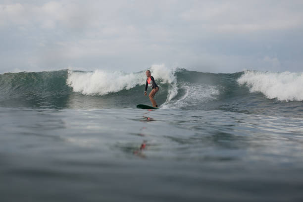 istock girl riding wave on surf board in ocean 928404444