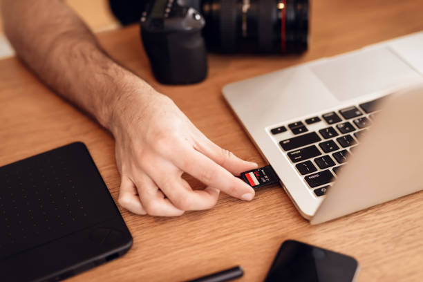 istock Close up freelancer bearded man using memory card at laptop sitting at desk. 928404644