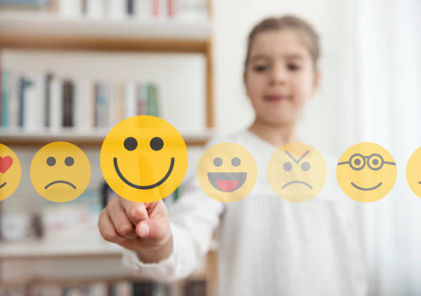 Kleines Mädchen, das Smiley-Emoji-Symbol auf dem Touchscreen berühren – Foto
