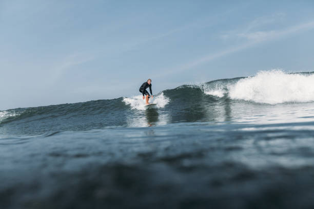 istock male surfer riding wave on surf board in ocean 928407096