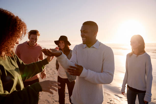 istock Friends Playing With Sand On Winter Beach Vacation 928407976