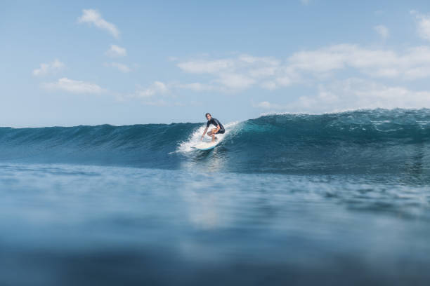 istock sportsman riding wave on surf board in ocean 928408230