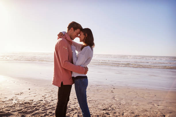 istock Romantic Couple On Walking Along Winter Beach Together 928408368