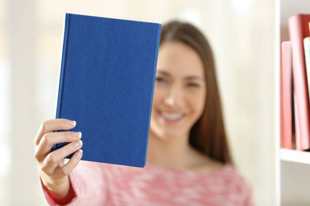 mulher mostrando uma capa em branco de um livro - presenter young adult women marketing - fotografias e filmes do acervo