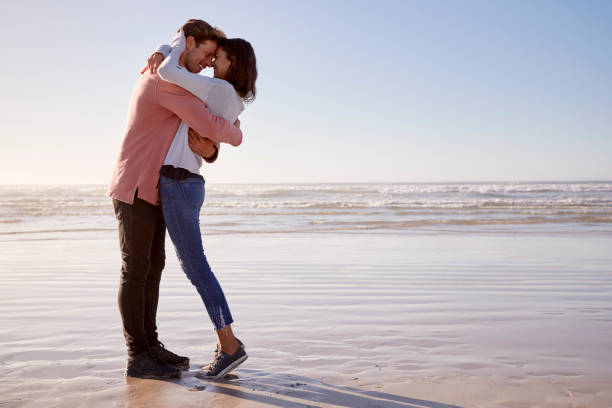 Romantic Couple On Walking Along Winter Beach Together