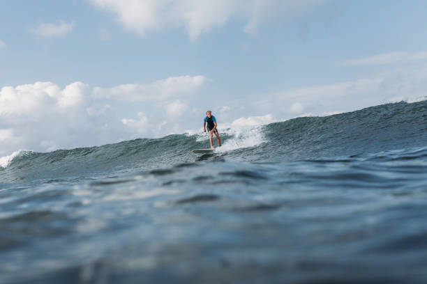 istock sportsman surfing wave on surf board in ocean 928410836