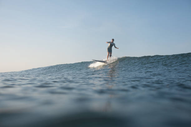 istock sportswoman surfing the wave on surf board in ocean 928411968