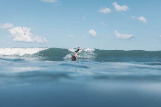 istock woman riding wave on surf board in ocean 928415046