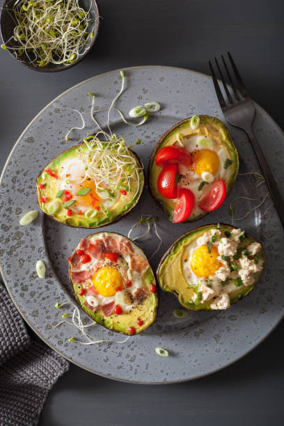 istock eggs baked in avocado with bacon, cheese, tomato and alfalfa sprouts 928415180