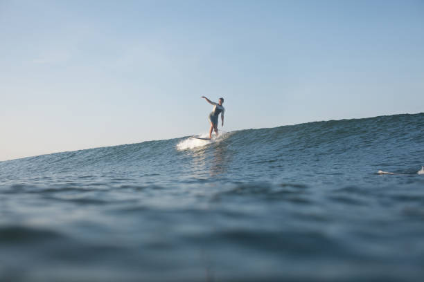 istock woman surfing the wave on surf board in ocean 928415224