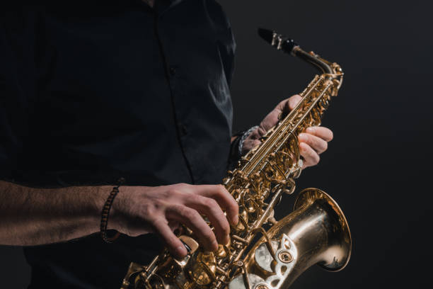 istock cropped shot of man playing saxophone on black 928418596