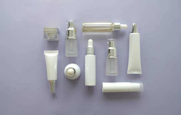 cosmetic packaging set on purple background. group of skincare cream serum oil . facial beauty cosmetic spa product. natural cosmetology concept skin treatment with green leaf and laboratory science glassware. envases cosméticos en fondo púrpura. grupo de aceite de suero crema cuidado de la piel. productos de cosmética spa de belleza facial. tratamiento de piel del concepto de cosmetología natural con verde hoja y laboratorio de cristalería de ciencia.